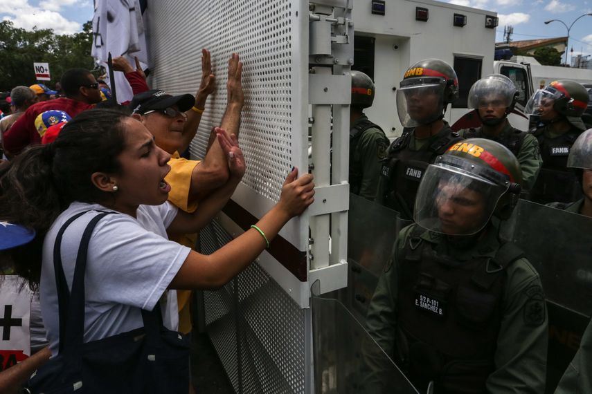 Manifestantes de la oposición venezolana gritan consignas a integrantes de la Guardia Nacional Bolivariana de&nbsp;Venezuela&nbsp;(GNB, policía militar) durante una marcha contra la sentencia del Tribunal Supremo de Justicia de&nbsp;Venezuela.&nbsp;