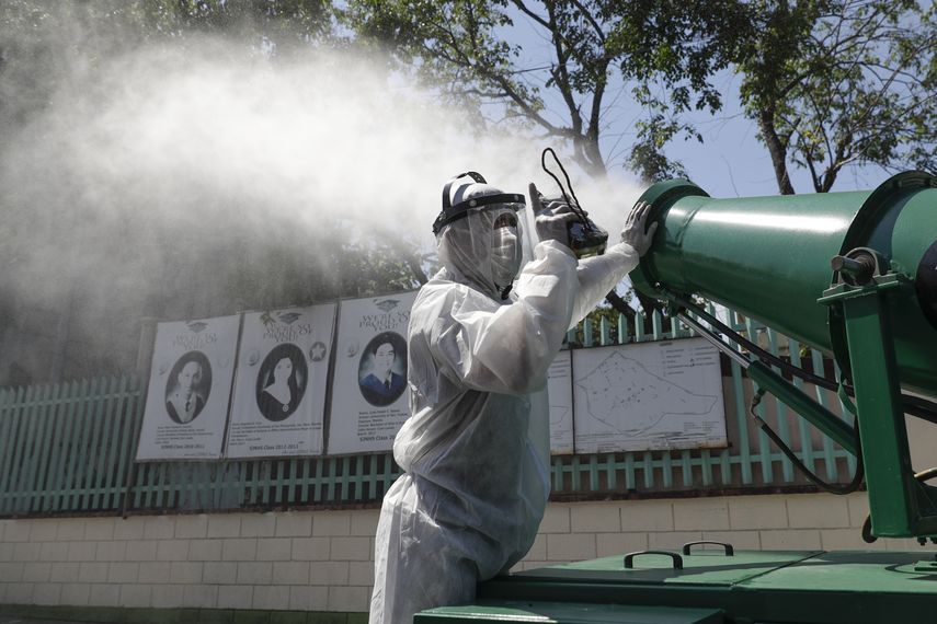 Un hombre controla un gran rociador de desinfectante, mientras sanean una escuela al este de Manila, Filipinas. &nbsp;