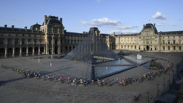 En esta foto del 28 de julio de 2019, el pelot&oacute;n del Tour de Francia pasa por la pir&aacute;mide del Museo del Louvre en Par&iacute;s.