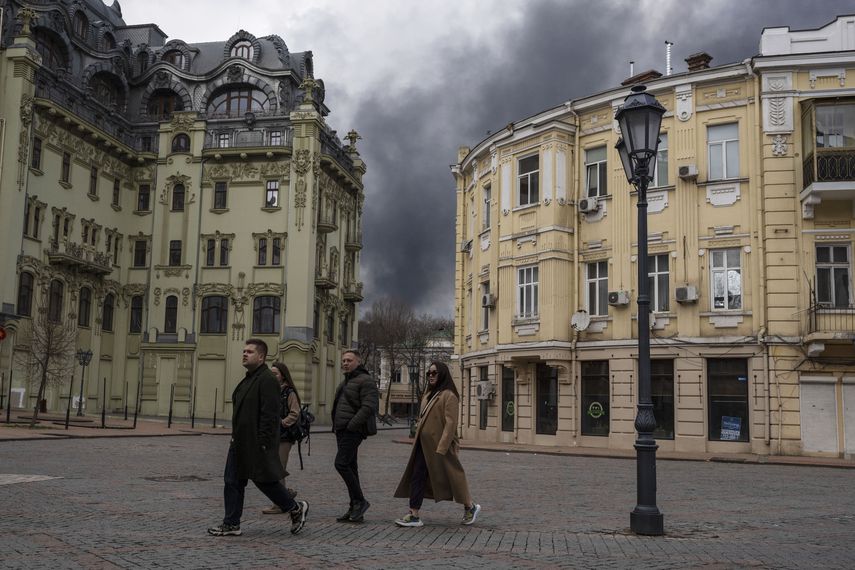 Personas caminan por una calle cerca de humo por un ataque en Odesa, Ucrania, el 3 de abril de 2022. Unesco puso a la ciudad en en su lista de lugares en peligro.