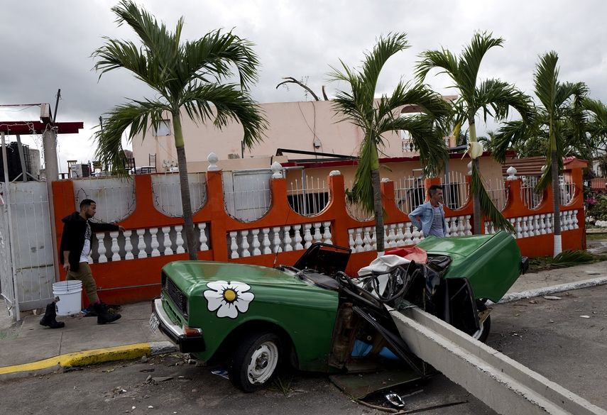 Un vehículo quedó destruido por un poste de luz que le cayó encima. 