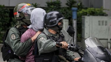 La Guardia Nacional Bolivariana (GNB) se lleva a un manifestante opositor durante una protesta.