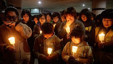 Gente reunida para orar por los pasajeros desaparecidos del transbordador hundido, el jueves 17 de abril de 2014, en la Escuela Secundaria Danwon, en Ansan, Corea del Sur. (AP)