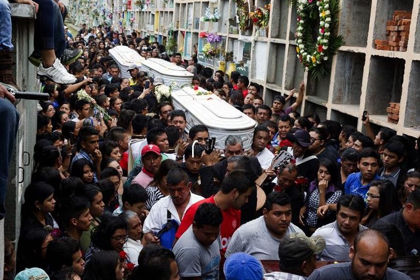 Amigos y familiares cargan los ataúdes de tres personas que murieron en el deslave en Santa Catarina Pinula. (EFE)