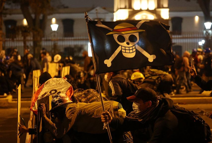 Manifestantes con una bandera del manga One Piece se enfrentan a agentes de la policía antidisturbios durante una protesta contra el presidente interino de Perú, José Jeri, en Lima el 15 de octubre de 2025.&nbsp;