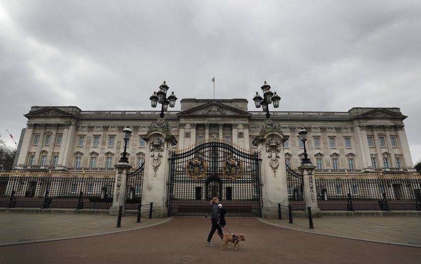 Una mujer camina con un perro y un bebé frente al Palacio de Buckingham el 23 de marzo de 2021. El gasto del presupuesto público de la monarquía británica aumentó 17% a 102,4 millones de libras esterlinas (124 millones de dólares) en el último año. Critican a realeza británica por aumento de sus gastos.