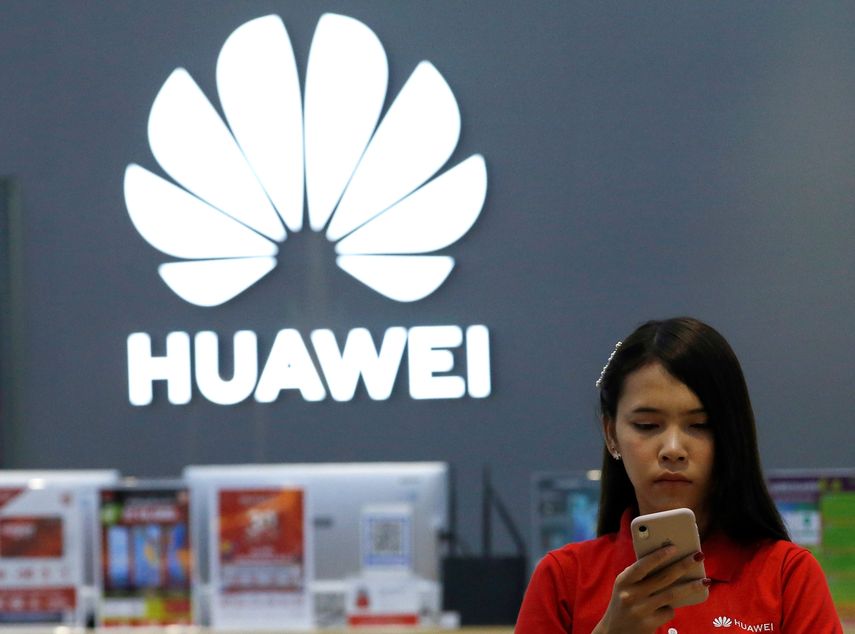 Una empleada revisa un teléfono Huawei en una tienda de la marca en Bangkok (Tailandia).