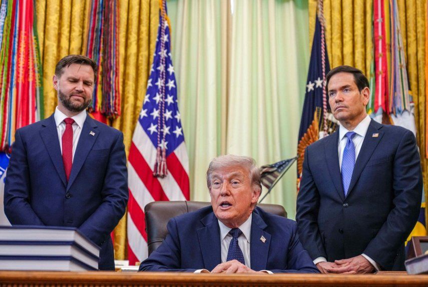 El vicepresidente JD Vance y el secretario de Estado Marco Rubio rodeando al presidente Donald Trump en la Oficina Oval de la Casa Blanca el 27ABR26.