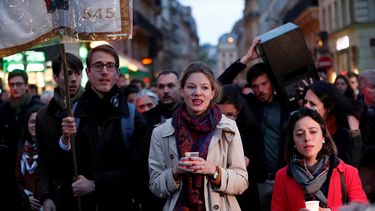 Decenas de personas marchan en tributo a la Catedral de Notre Dame, afectada por un voraz incendio este martes, en París, Francia.