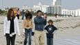 Un grupo de turistas se protegen del inesperado frío que llegó ayer a las costas de Miami, mientras pasean por la playa.