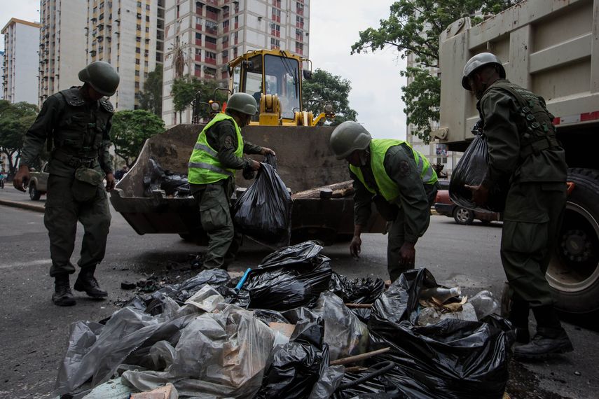 Militares recogen escombros &nbsp;tras los destrozos ocasionados por una serie de&nbsp;saqueos&nbsp;ocurridos anoche en Caracas&nbsp;
