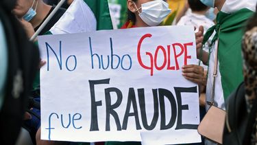 Una opositora al gobierno del presidente boliviano Luis Arce sostiene un cartel que dice No fue un golpe, fue un fraude mientras participa en una protesta contra el arresto de la ex presidenta interina Jeanine Anez y sus exministros en Santa Cruz, Bolivia. , el 15 de marzo de 2021.