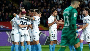 Jugadores del Girona celebran el tanto para abrir el marcador de Artem Dovbyk en el encuentro ante el Barcelona en la liga española en el estadio Olimpic Lluis Companys, el domingo 10 de diciembre del 2023.