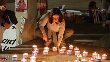 Una mujer enciende velas en honor a los israelíes inocentes que el grupo terrorista Hamás mantiene como rehenes.