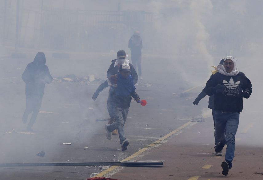 Manifestantes&nbsp;contrarios al gobierno de Len&iacute;n Moreno&nbsp;corren en medio de una nube de gases lacrim&oacute;genos durante enfrentamientos con la polic&iacute;a, mientras protestan por las pol&iacute;ticas econ&oacute;micas, en Quito, Ecuador, el martes 8 de octubre de 2019.