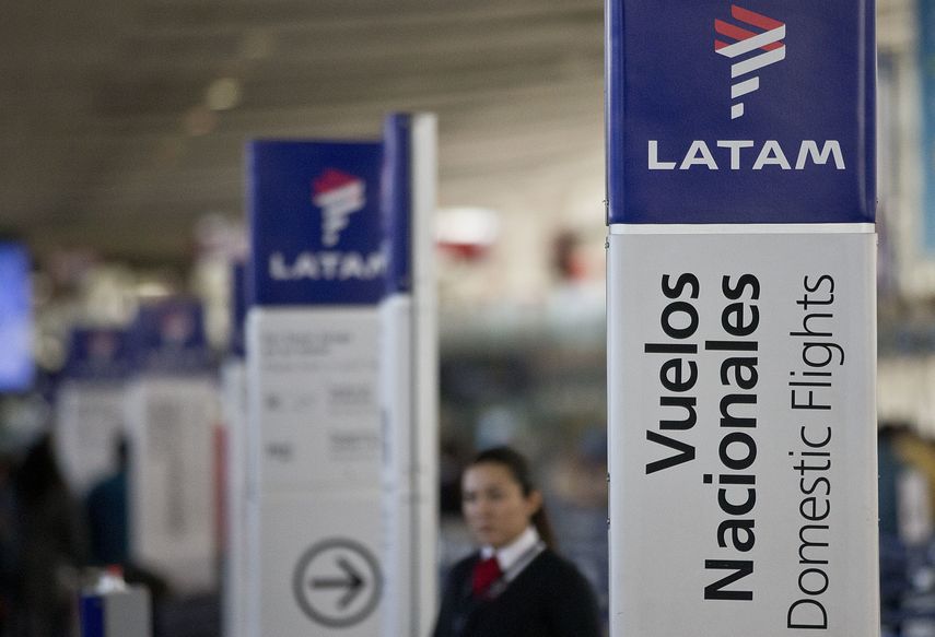 Una empleada de LATAM Airlines junto a los mostradores de facturaci&oacute;n en el aeropuerto de Santiago de Chile.&nbsp;