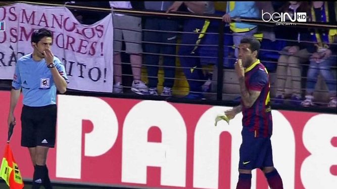 Dani Alves en el momento que muerde la banana que fue lanzada por un hincha. (ARCHIVO)