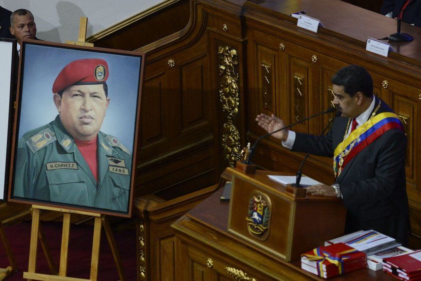 Junto a una foto de su predecesor, el difunto Hugo Chávez, el dictador del régimen de Venezuela, Nicolás Maduro, da su discurso anual a la nación ante miembros de la Asamblea Constituyente en los terrenos de la Asamblea Nacional en Caracas, Venezuela, el martes 14 de enero de 2020.