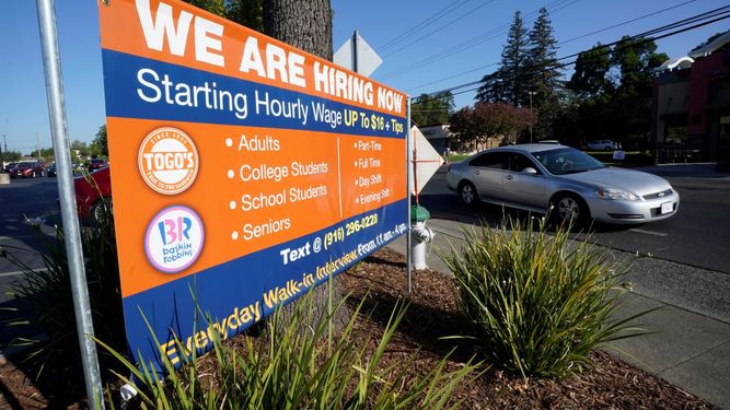 Un auto pasa frente a un letrero de contratación laboral en Sacramento, California &nbsp;