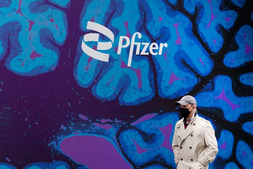 Un hombre camina junto al edificio del gigante farmacéutico Pfizer, en Nueva York.