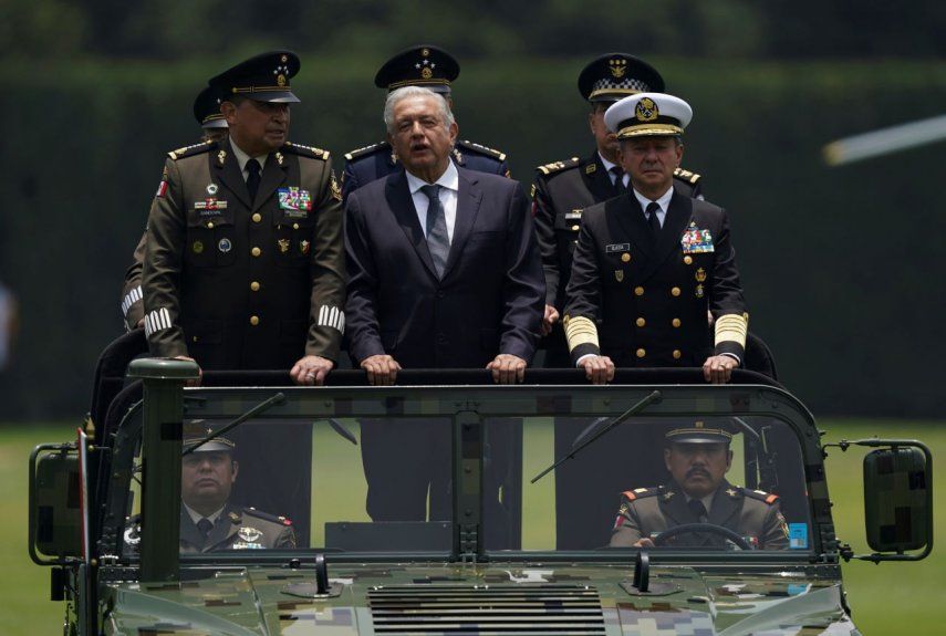 El presidente de México, Andrés Manuel López Obrador, en el centro; el secretario de Defensa, Luis Cresencio Sandoval, a la izquierda, y el comandante naval José Rafael Ojeda viajan en un vehículo militar durante un desfile de presentación del nuevo comandante del ejército, en Ciudad de México.