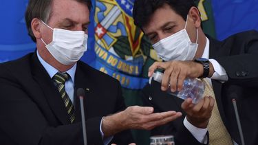 &nbsp; El ahora exministro de salud de Brasil Luiz Henrique Mandetta, derecha, aplica desinfectante en las manos al presidente Jair Bolsonaro durante una conferencia de prensa en el Palacio Presidencial de Planalto en Brasilia, el 18 de marzo del 2020.