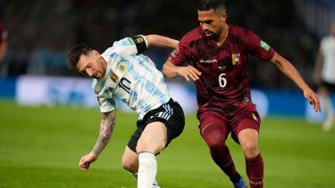 Lionel Messi de Argentina, a la izquierda, y Yangel Herrera de Venezuela luchan por el balón durante un partido de clasificación para la Copa Mundial de la FIFA Catar 2022, en el estadio de la Bombonera en Buenos Aires, Argentina, el viernes 25 de marzo de 2022.