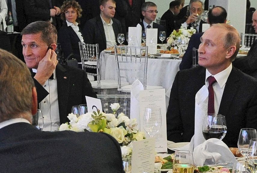 Foto de archivo tomada el 10 de diciembre de 2015, que muestra al presidente ruso Vladimir Putin (dcha), sentado junto al entonces militar retirado estadounidense Michael T. Flynn (izq), durante un encuentro para celebrar el 10º aniversario de la cadena de televisión Russia Today, &nbsp;en Moscú.&nbsp;