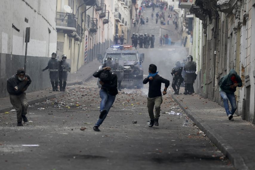Manifestantes corren delante de un veh&iacute;culo armado durante choques con la polic&iacute;a en Quito, Ecuador, el mi&eacute;rcoles 9 de octubre de 2019.