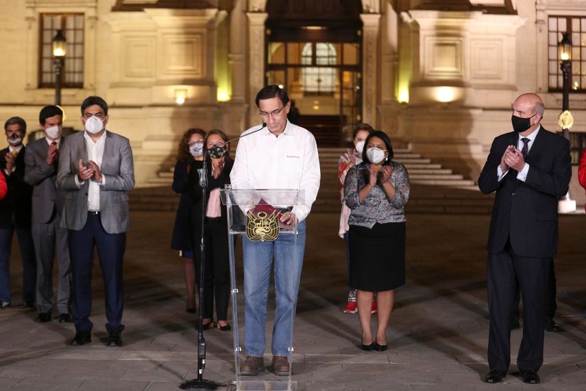 El presidente de Perú, Martín Vizcarra, baja la mirada mientras miembros de su gabinete lo aplauden frente al palacio presidencia en Lima, después de que el Congreso aprobó su destitución el lunes 9 de noviembre de 2020.&nbsp;