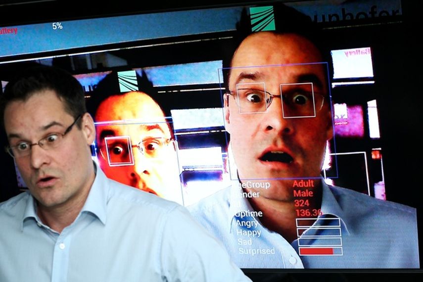 Jens Garbas, del equipo del Fraunhofer Institut de Erlangen, junto a un monitor que analiza su cara mediante un software de reconocimiento facial. Foto DPA