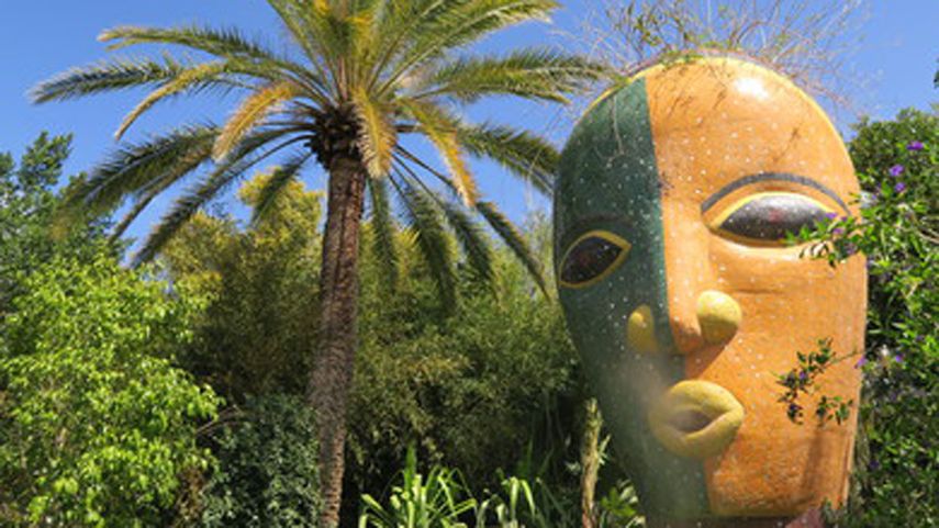 Plantas exóticas crecen alrededor de obras de arte.