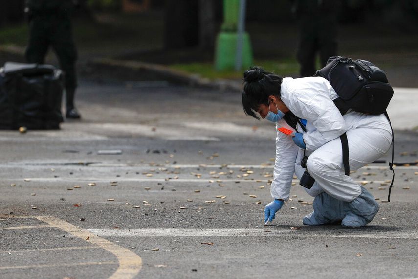 Una investigadora forense recopila cartuchos de bala en el lugar de un ataque al jefe de la polic&iacute;a de la Ciudad de M&eacute;xico a manos de pistoleros, el 26 de junio de 2020.&nbsp;
