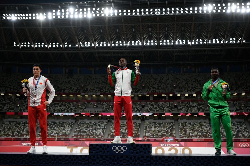 El medallista de oro portugués Pedro Pablo Pichardo (C), nacido en Cuba, el medallista de plata de China Zhu Yaming (izq.) y el medallista de bronce de Burkina Faso Hugues Fabrice Zango (der.) posan en el podio después del evento de triple salto masculino durante los Juegos Olímpicos de Tokio 2020