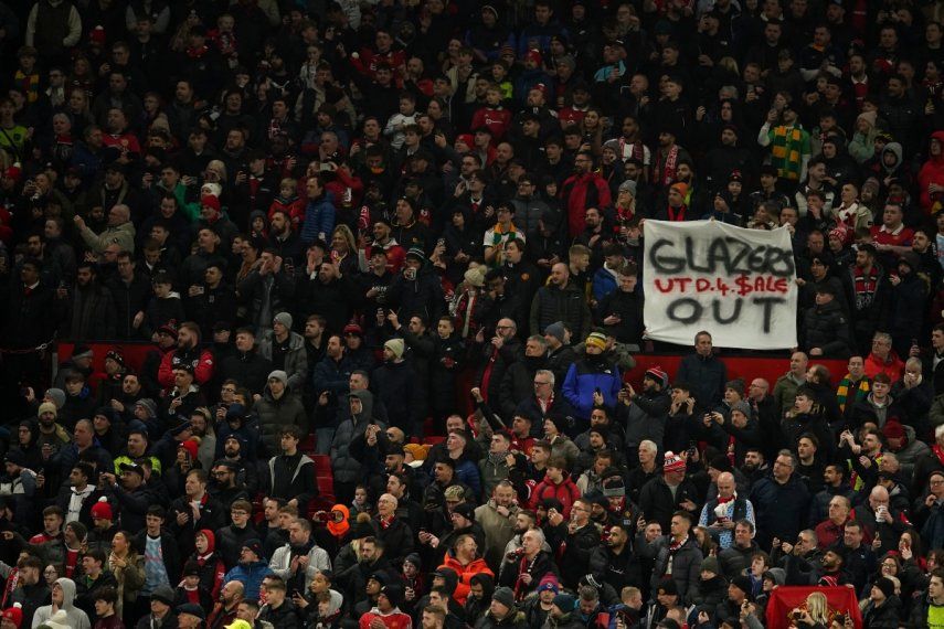 En foto del primero de febrero de 2023, aficionados del Manchester United sostienen una pancarta con la frase Glazers Out durante el duelo de vuelta de semifinal de la Copa de Liga.