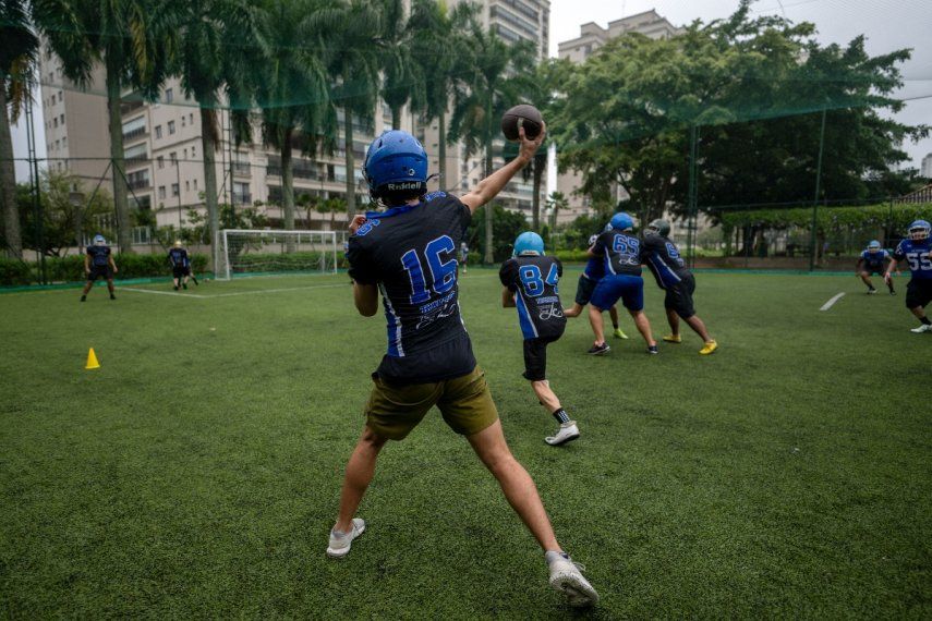 Un jugador de fútbol americano lanza el balón durante una sesión de entrenamiento del equipo de la Academia de Fútbol de Río dentro del condominio de lujo Península, ubicado en el barrio de Barra da Tijuca en Río de Janeiro, Brasil, el 24 de enero de 2024. Gritando y gesticulando ante la televisión en Con su camiseta y bufanda de los San Francisco 49ers, el programador informático brasileño Carlos Marins desea que su equipo recupere la ventaja y llegue al Super Bowl. No es un expatriado desarraigado que ve los playoffs de la NFL en Estados Unidos. Este es un bar en el Brasil tropical, la tierra de Neymar, Ronaldo y Pelé, donde otro fútbol, el americano, está en auge. &nbsp;