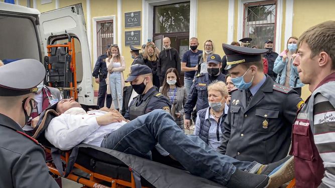 En esta imagen distribuida por Radio Free Europe/Radio Liberty, agentes y paramédicos introducen en una ambulancia a Stsiapan Latypau, un activista bielorruso que intentó suicidarse durante una audiencia judicial en protesta por la represión política, en Minsk, Bielorrusia, martes 1 de junio de 2021.&nbsp; &nbsp;