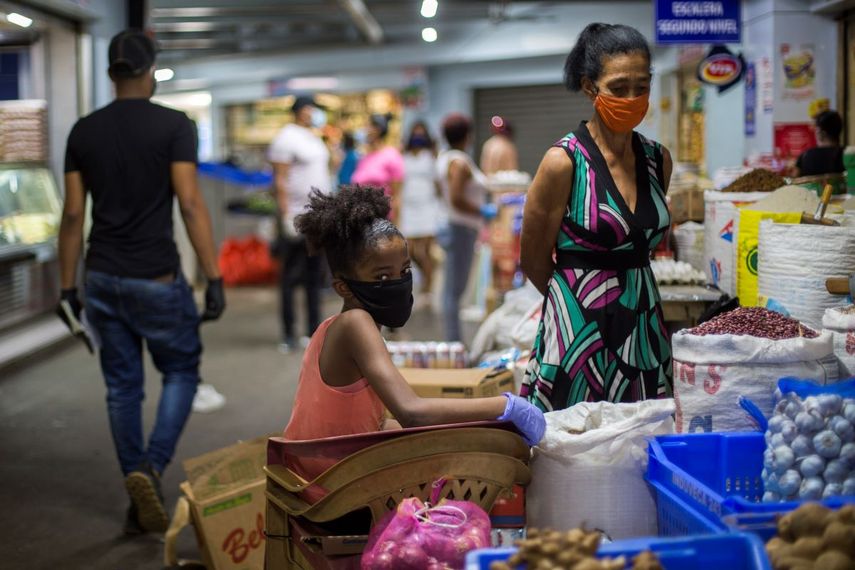 Una mujer y una ni&ntilde;a se cubren el rostro para prevenir el contagio del coronavirus en un mercado. Las elecciones presidenciales y parlamentarias de Rep&uacute;blica Dominicana previstas para el 17 de mayo, fueron pospuestas para el 5 de julio debido a la pandemia del coronavirus