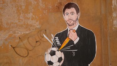 Un mural con una imagen del presidente de Juventus abriéndole un agujero a una pelota de fútbol, en Roma, el jueves 22 de abril de 2021