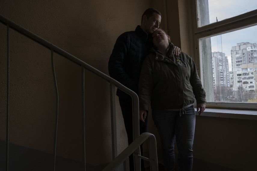 Iryna y Volodymyr, desplazados internos de Irpin, se apoyan el uno en el otro, en un descanso de la escalera cerca del apartamento donde se refugiaron con otros cuatro adultos de Irpin, en Leópolis, Ucrania, el domingo 3 de abril de 2022.&nbsp;