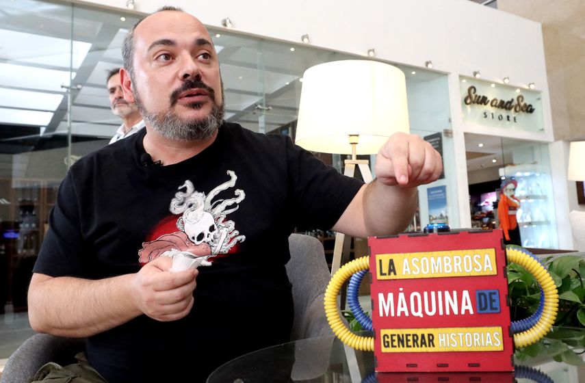 El español Jorge Gonzalvo, escritor creativo y director de la organización Atrapavientos, muestra La asombrosa máquina de generar historias durante una entrevista con la AFP sobre Inteligencia Artificial en la Feria Internacional del Libro de Guadalajara, México, el 26 de noviembre de 2023.