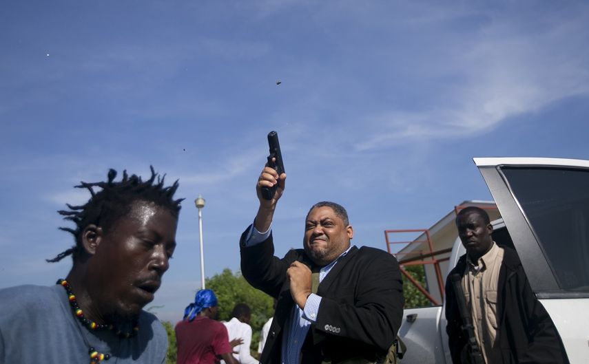 Momento en el que el senador&nbsp;haitiano&nbsp;Ralph Fethiere dispara su pistola en las afueras del Parlamento en Puerto Pr&iacute;ncipe, Hait&iacute;, el lunes 23 de septiembre de 2019.