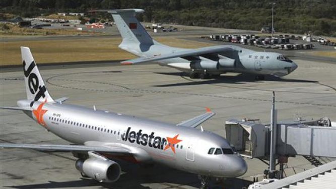 Un avión chino Ilyushin IL-76s pasa frente a una aeronave comercial en el Aeropuerto Internacional de Perth, Australia. (Foto AP/Rob Griffith)