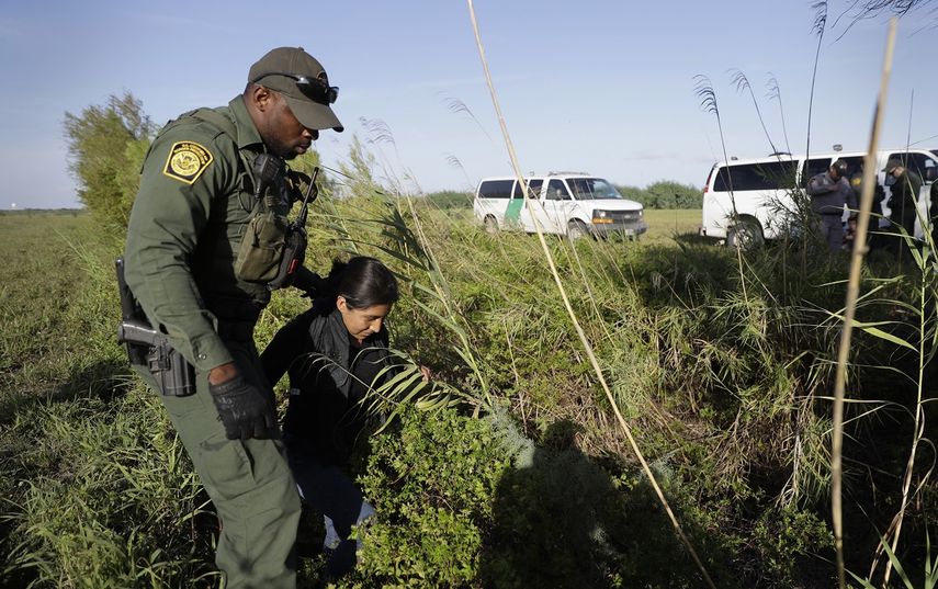Un agente de Aduanas y Protección Fronteriza detiene a una persona inmigrante que cruzó ilegalmente hacia Estados Unidos por el Rio Grande (río Bravo para México) cerca de Granjeno, Texas.&nbsp;