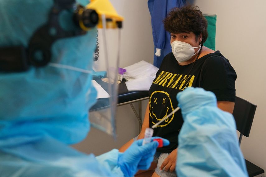 Un trabajador de la salud vestido con equipo de protección toma muestras de una mujer para detectar la enfermedad COVID-19 en el centro de salud de La Jota en Zaragoza el 10 de agosto de 2020. España ha agregado 19.405 nuevos casos de coronavirus la semana pasada, pero el Ministerio de Salud dice el país no está entrando en una segunda ola de la pandemia.
