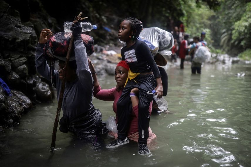 Migrantes haitianos caminan por el agua mientras cruzan el Tapón del Darién, de Colombia a Panamá con la esperanza de llegar a EEUU, el 9 de mayo de 2023. EEUU activa un nuevo programa para favorecer a ciudadanos de Haití, Nicaragua, Cuba y Venezuela.
