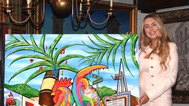La artista cubanoamericana Laura Chirino posa junto a El gallo fino, obra conmemorativa de la edición 2022 de Carnaval Miami. 