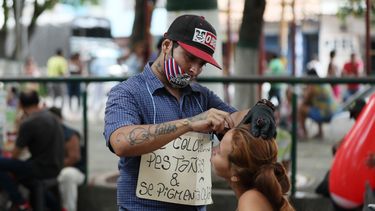El venezolano Ángel&nbsp;García,publicita su trabajo con un trozo de cartón que lleva colgando del pecho y en el que dice Se colocan pestañas y se pigmentan cejas