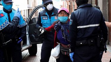 La policía metropolitana detiene a una vendedora de fruta callejera, lo cual está prohibido debido al coronavirus, en Quito, Ecuador, el viernes 10 de abril de 2020. 
