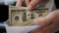 Persona con un sobre de billetes de 100 dólares&nbsp;